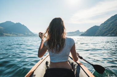 Lady on a kayak rowing.